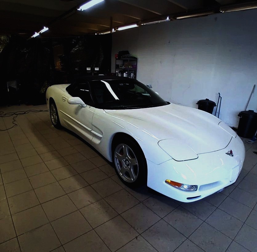 Hvit Corvette cabriolet inne i verkstedet