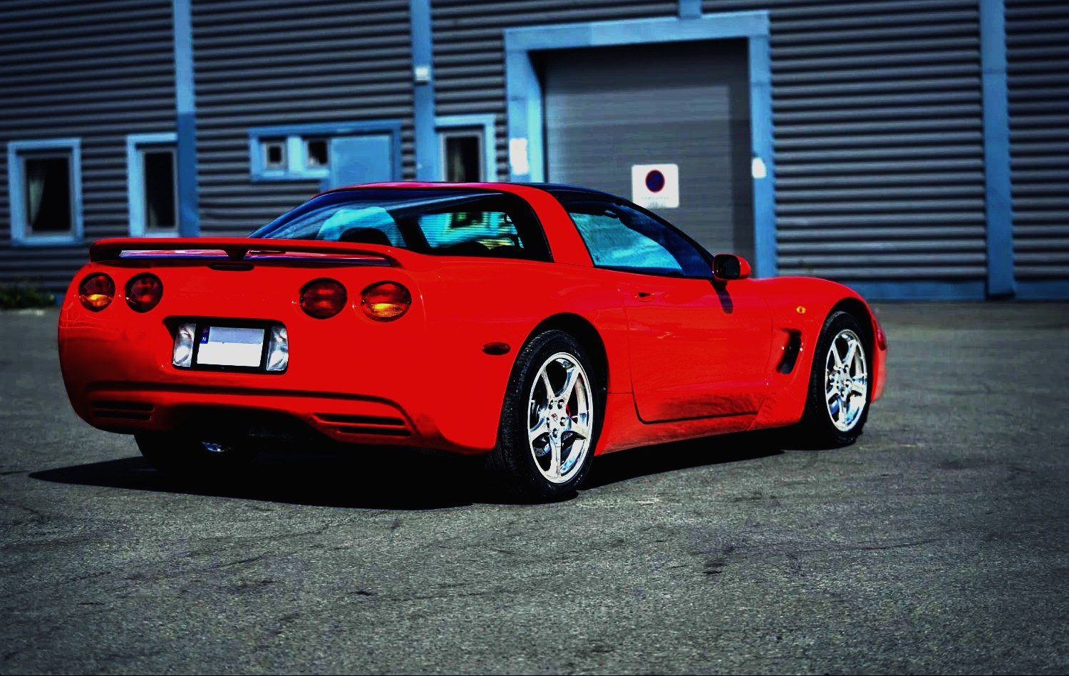 Rød Corvette sett bakfra utenfor verkstedet