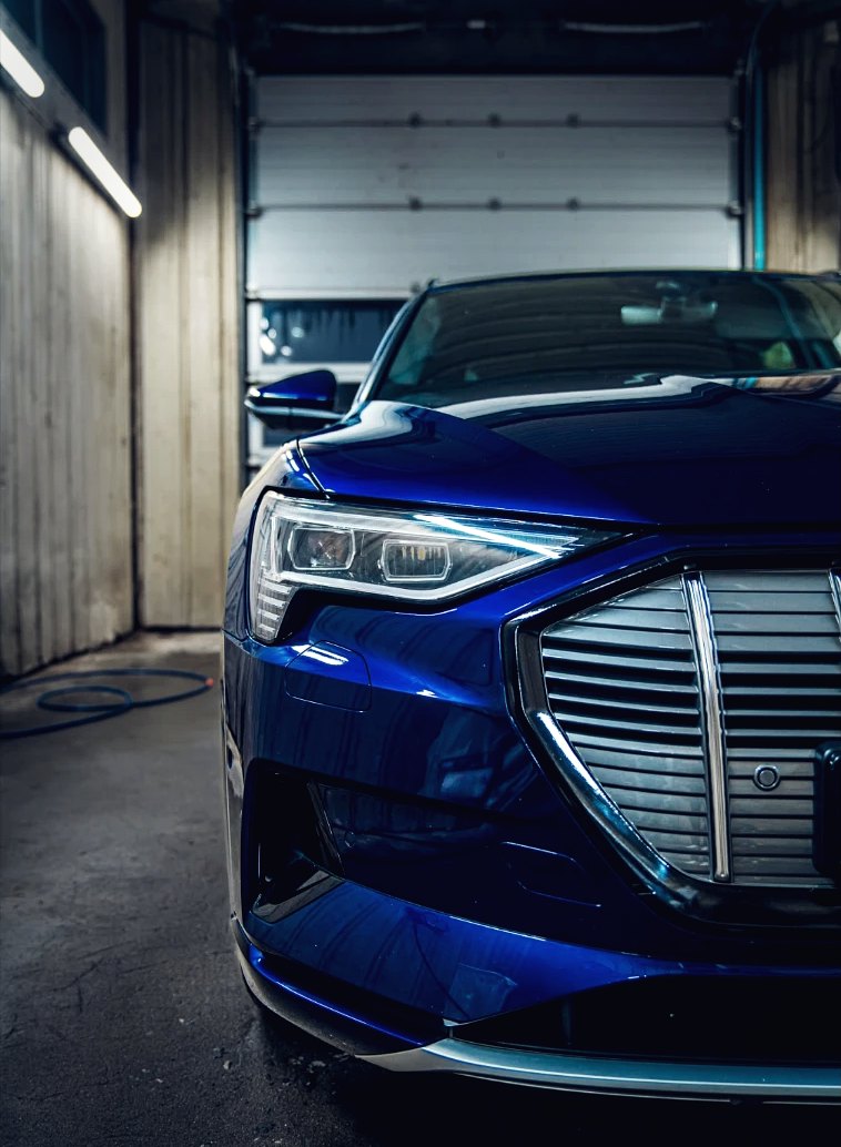 Blå Audi e-tron sett forfra i verkstedet