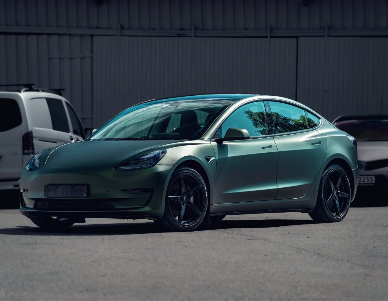 Tesla Model 3 helfoliert i satin militærgrønn, sett fra siden