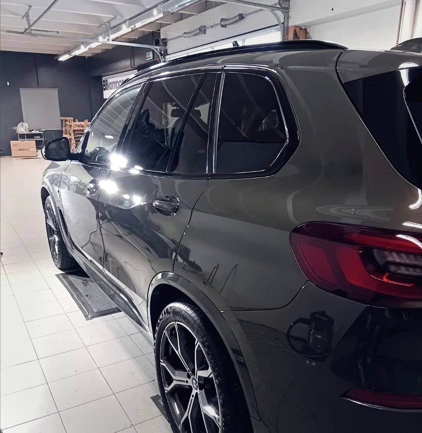 BMW X5 med solfilm på sideruter og bakrute, inne i verkstedet